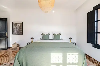 a bedroom with a large bed with a green blanket at Magnifique Villa EME, Golf Amelkis Marrakech - Piscine Chauffée in Marrakech