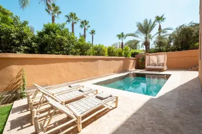 a swimming pool with two lounge chairs and a swimming pool at Magnifique Villa EME, Golf Amelkis Marrakech - Piscine Chauffée in Marrakech
