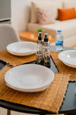 a table with plates and bottles on top of it at 1BR Cosy 2 min M Avenue Parking, Piscine & Fibre in Marrakech
