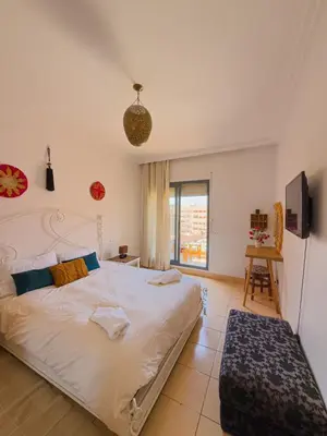 a bedroom with a large bed and a tv at Cozy appartment - private terrace - Gueliz in Marrakech