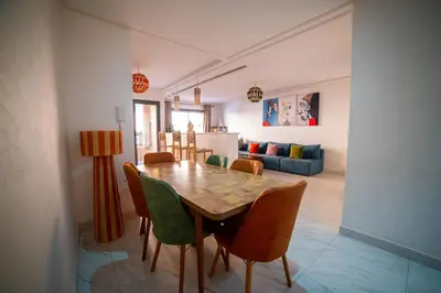 a dining room and living room with a table and chairs at Les cristaux de Marrakech in Marrakech