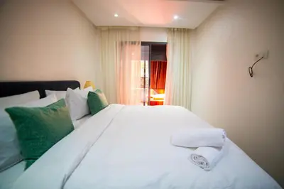 a bedroom with a large white bed with green pillows at Les cristaux de Marrakech in Marrakech