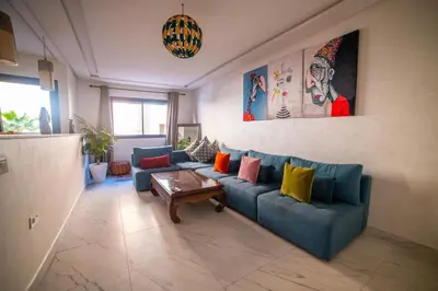 a living room with a blue couch with colorful pillows at Les cristaux de Marrakech in Marrakech