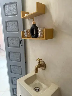 a sink in a bathroom with aaucet on a wall at White Riad Residence in Oulad Akkou