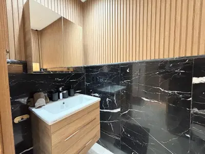 a bathroom with a sink and a black marble wall at Verona Studio - 1 Bedroom Piscine & Rooftop in Marrakech