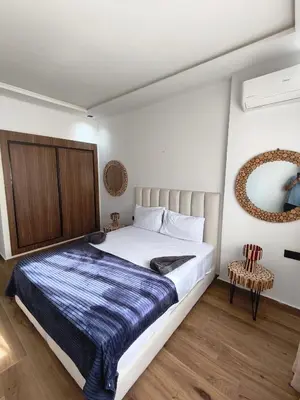 a bedroom with a bed and a mirror at Appartement a Menara garden in Marrakech