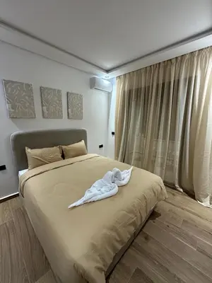 a white robe laying on a bed in a bedroom at Studio a Menara garden in Marrakech