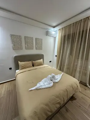 a white robe laying on a bed in a bedroom at Studio a Menara garden in Marrakech