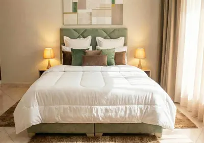 a bedroom with a large white bed with two lamps at Appart Mobarak 5 in Marrakech