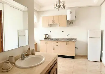 a kitchen with a sink and a white refrigerator at Appart Mobarak 5 in Marrakech