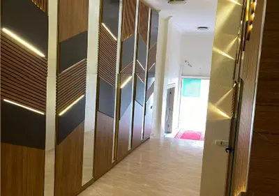 a hallway with a wooden door and a room with a floor at Appart Mobarak 5 in Marrakech