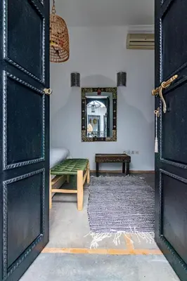 a room with an open door with a bench and a mirror at Maison Meurisse Tlata private and Daily Breakfast in Marrakech