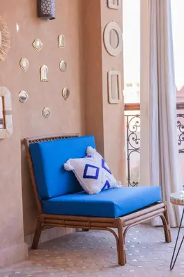 a blue chair with a pillow on a balcony at Sublime appartement 2 chambres en plein centre entre Gueliz et hivernage avec piscine in Marrakech