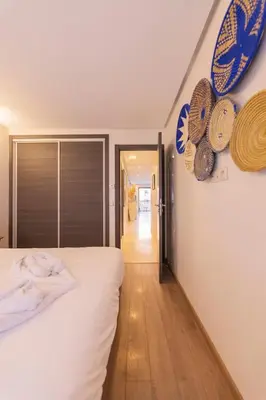 a bedroom with a bed and some hats on the wall at Sublime appartement 2 chambres en plein centre entre Gueliz et hivernage avec piscine in Marrakech