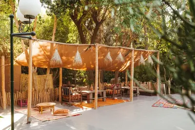 a canopy over a patio with tables and chairs at Oasis Garden Marrakech in Marrakech