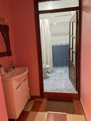 a bathroom with a sink and a toilet and a door at Appartement meublé calme près de l'aéroport menara in Marrakech