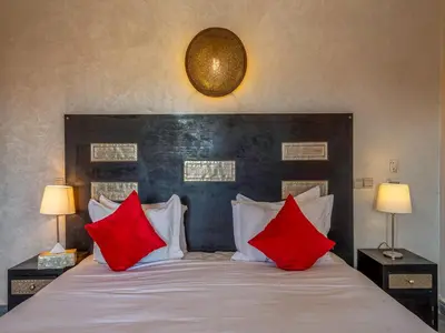a bedroom with a large bed with red pillows at Hôtel Boutique RAM SPA in Marrakech