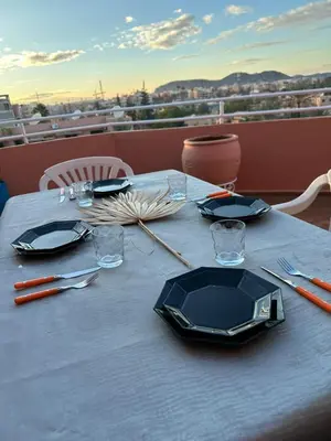 a blue table with plates and utensils on a balcony at Appartement avec piscine Vue colline à Gueliz in Marrakech