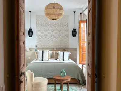 a bedroom with a bed and a table and a chair at Riad melqa piscine privée - Medina Marrakech in Marrakech