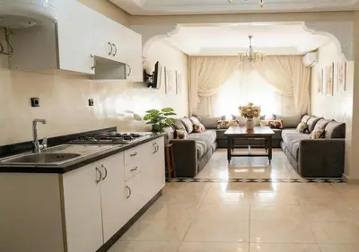 a kitchen and living room with a couch and a table at Appart de luxe 3 in Marrakech