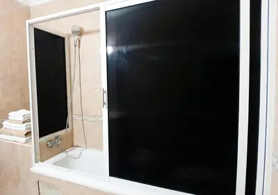 a black shower door in a bathroom with a mirror at Appart de luxe 3 in Marrakech