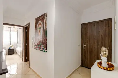a room with a white wall with a wooden door at Spacious Can 2025 Iptv Guéliz 7 min away in Marrakech