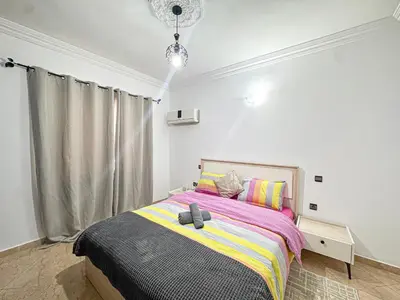 a bedroom with a bed with a purple and yellow blanket at Urban Cocoon Quiet and modern in Marrakech