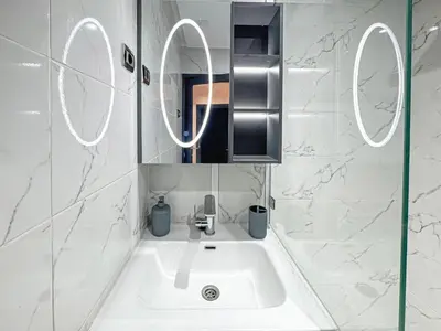 a white bathroom with a sink and a mirror at Urban Cocoon Quiet and modern in Marrakech