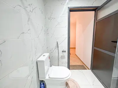 a white bathroom with a toilet and a shower at Urban Cocoon Quiet and modern in Marrakech