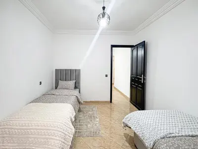 a row of beds in a room with white walls at Urban Cocoon Quiet and modern in Marrakech