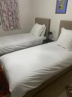 two beds in a room with white sheets and pillows at Appartement hivernage in Marrakech