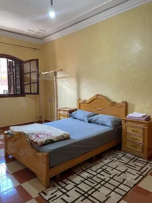 a bedroom with a bed with a wooden frame and a dresser at Appartement proche de l'airoport in Marrakech