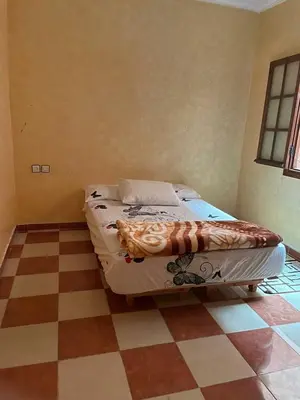 a bed in a room with a checkered floor at Appartement proche de l'airoport in Marrakech
