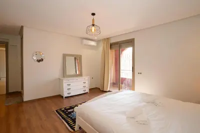 a bedroom with a white bed and a mirror at Maison M, Spacious 2-Bedroom Apartment in Marrakech in Marrakech