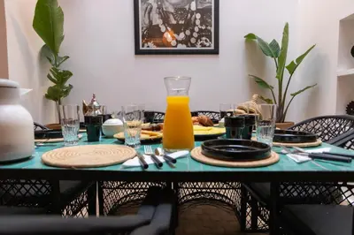 a table with a plate of food and a glass of orange juice at Maison Meurisse KHAMSaPrivate pool and breakfast in Marrakech