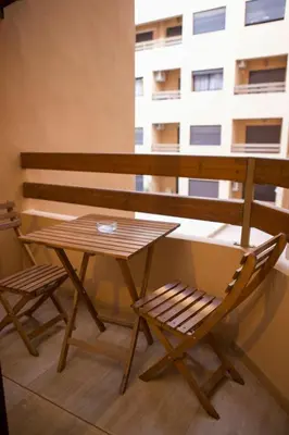 a wooden table and a chair on a balcony at Le Loft Chic Hivernage Piscine & Parking Privé in Marrakech