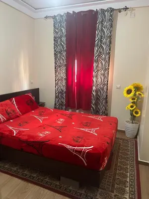 a bedroom with a red bed with a red blanket at Appt á louer TF2 in Marrakech