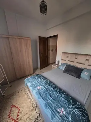 a bedroom with a bed with a blue comforter at Beautiful comfortable apartment in a secure residence in Marrakech
