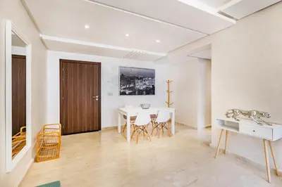 a dining room with a table and chairs and a door at Résidence jnan ali 4 Marrakech in Marrakech