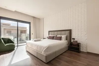 a bedroom with a large bed and a large window at Villa Sunstone Marrakech in Marrakech