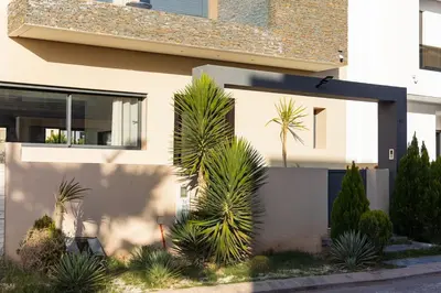 a house with palm trees in front of it at Villa Sunstone Marrakech in Marrakech