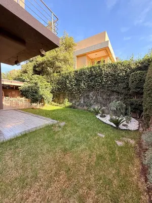 a house with a garden in front of a building at Vibrant Modern House, 20 Min from Gueliz & Airport in Marrakech