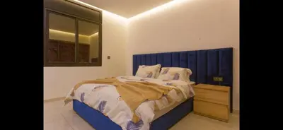 a bedroom with a large bed with a blue headboard at Modern 3-Bed retreat in Gueliz near Train station in Marrakech