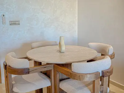 a table and chairs with a vase on top of it at Prestigia Argan 2Ch Piscine et Parking 6pax in Marrakech