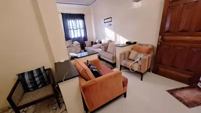 a living room with couches and chairs and a door at Espacieuse in Marrakech