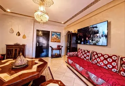 a living room with a red couch and a table at Cozy apartment, traditional style, mountain view in Marrakech