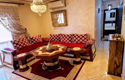 a living room with a red couch and a table at Cozy apartment, traditional style, mountain view in Marrakech
