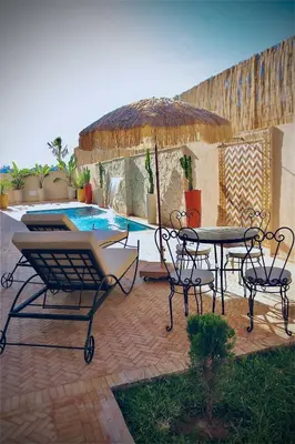 a patio with a table and chairs and a pool at Luxury Villa Hedi in Marrakech