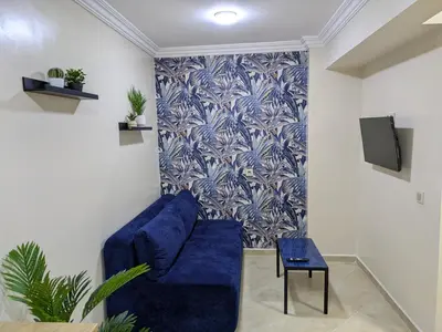 a living room with a blue couch and a tv at Majorelle blue SPA retreat in Marrakech