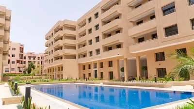 a hotel with a swimming pool in front of a building at Modern Duplex Apartment in Marrakech for family only - Comfortable Quiet in Marrakech